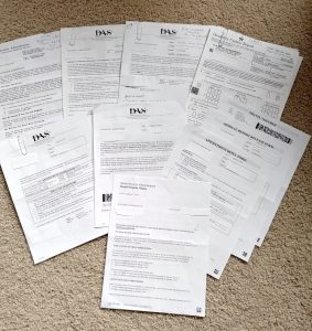 An arrangement of many pieces of paper from the Social Security Administration and offices of Disability Adjudication Services.