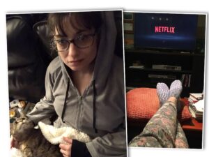 Two photos side by side; they are placed slightly askew of each other. The left photo is of a female wearing a grey hoodie. She is also wearing glasses, and her hair is messy. On her lap is a fuzzy white blanket, with a tabby cat on top of it and looking upwards. In the corner, to her left, are a few tubs of lotion, lip balm, and pain creams. The right photo is of a pair of crossed legs in grey and pinkish PJ pants; the feet, clad in multi-colored grey and purple socks, are resting on an orange pillow, which is on a coffee table. The top of the photo is dark; it shows a TV with the red Netflix logo on the screen; it is on a TV stand.